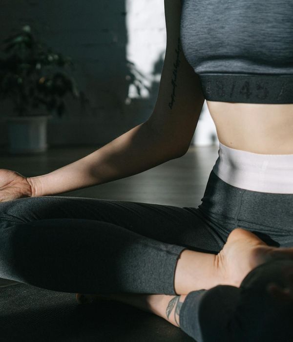 Woman meditating in a peaceful evening yoga pose indoors.